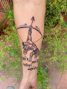 a person with a tattoo on their leg holding a bow and arrow in one hand