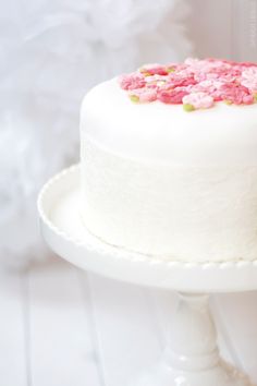 a white cake with pink and green sprinkles sitting on top of it