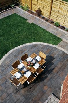 an overhead view of a table and chairs on a patio with grass in the background