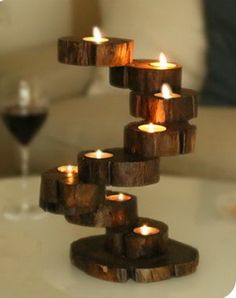 candles are arranged in the shape of a spiral on top of a table with wine glasses next to it