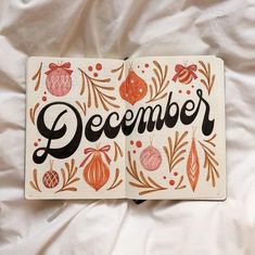 an open book with the word december written in black and red on it's cover