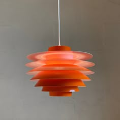 an orange light fixture hanging from a ceiling