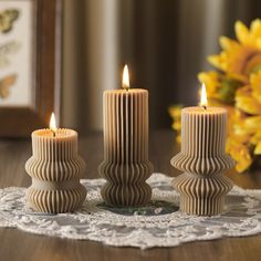 three candles sitting on top of a doily