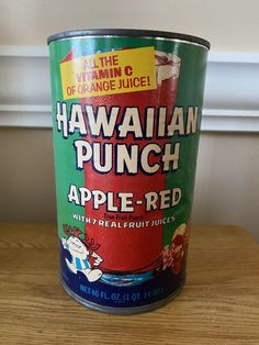 a can of hawaiian punch apple - red on a wooden table in front of a window