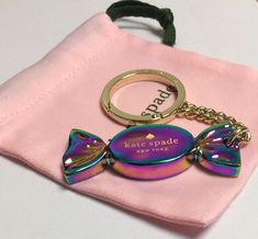 a keychain that is sitting on top of a pink cloth with a fish charm