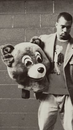 a man is holding a large stuffed animal