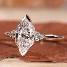 an engagement ring with a large diamond in the center and two smaller diamonds on each side