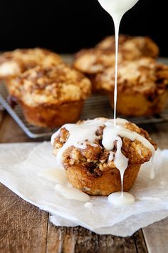 a muffin being drizzled with white icing on top of it