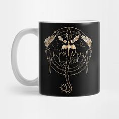 a black and gold coffee mug with an image of a fairy on it