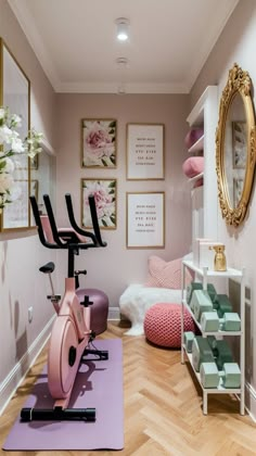 there is a pink exercise bike in the room with pictures on the wall behind it