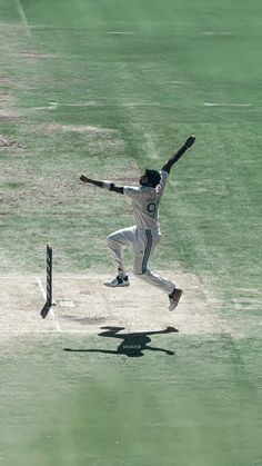 a baseball player is running to catch the ball and hitting it with his bat in mid air