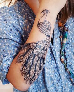 a woman with a peacock tattoo on her arm