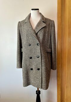 "This is a very good classic style. Very timeless Women's wool overcoat. Plus size.. grey and off white weave with subtle flecks of blue , red and other sprinkled in. Although those flecks don't really read so much but upon very close up. Mostly it looks like a warm grayish- natural off white.  It's not actually double breasted but it has that look similar to a peacoat style. (But it's not of course) The only flaws or some older water like spots on the inner purple satin lining. The wool coat it Peacoat Style, Tweed Overcoat, 90s Era, Wool Overcoat, White Tweed, Purple Satin, Vintage Wool, Wool Coat, Double Breasted