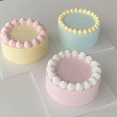 three cakes sitting on top of each other in different shapes and sizes, all decorated with icing