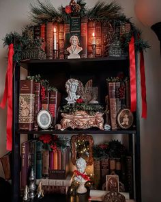 a shelf filled with lots of books covered in christmas decorations and candles on top of it