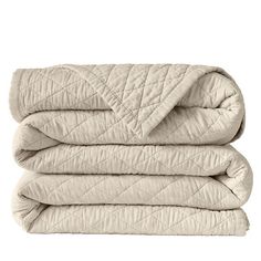 three blankets stacked on top of each other in beige colors, with one blanket folded over the