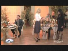 two women and a man are standing in front of a table with food on it