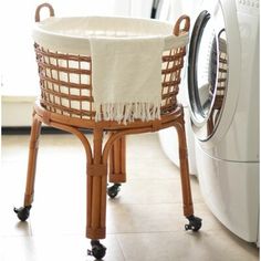 a laundry basket sitting on top of a washer next to a dryer in a room