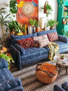 a living room filled with blue couches and lots of plants