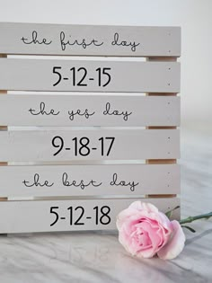 a wooden sign that says the first day and the last day with a pink rose