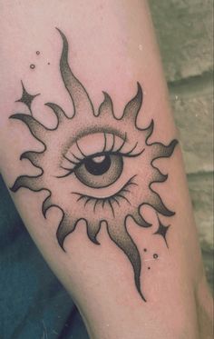 a tattoo with an eye on the arm and sun in the middle, as well as stars