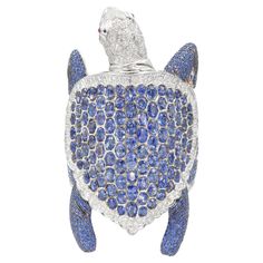 De Grisogono Sapphire and Diamond "Turtle" bracelet. The bracelet features shell of the turtle made in honey comb design, set with oval cut sapphires (weighing approximately 85.90ct), surrounded by pave set round brilliant cut diamonds around the edges, round brilliant cut diamond pave (Total diamond weight is approximately 13.85ct) set head with cabochon cut ruby eyes, the legs and body encrusted in round cut sapphires (weighing a total of 72.90ct). Equipped with push lock. Inscribed: de Grisogono, Geneve, S85.90 / 72.90, D13.85, 750. Stamped with makers marks. Turtle measures: 130mm by 80mm. Width at the back 62mm. Inner Circumference: about 7 inches. Weight: 342.00 grams Comb Design, Turtle Bracelet, Bracelet Tennis, Ruby Bracelet, Modern Bracelets, Bracelet Love, Star Ruby, Brown Diamond, Sapphire Stone