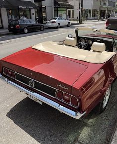 a red convertible car parked on the side of the road