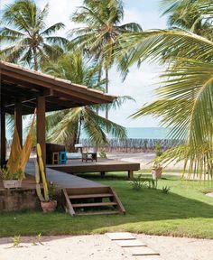 a house on the beach with hammocks and palm trees