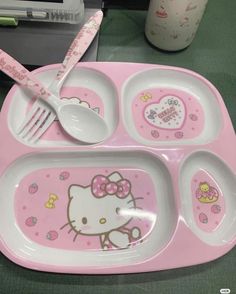 a pink hello kitty plate with spoons and fork