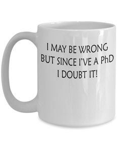 a white coffee mug that says i may be wrong but since i've a phd