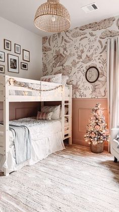 a white bunk bed sitting in a bedroom next to a christmas tree on top of a rug