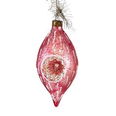 a pink ornament hanging from a wire on a white background with water droplets