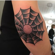 a spider web tattoo on the arm