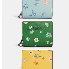 three wallets with flowers on the front and one in blue, yellow and green