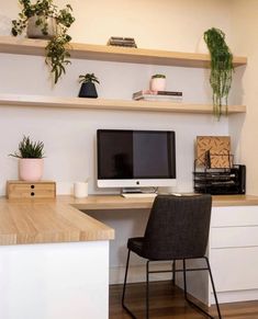 an instagram photo of a desk with a computer on it and some plants in the corner