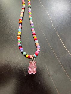 Handmade gummy bear necklace. Multicolored seed beads and a pink gummy bear charm.  length: 20 inches  closure: lobster clasp  charm: pink gummy bear  Please feel free to reach out to me with any questions or to discuss a custom order. Cute Pink Beaded Chain Jewelry, Pink Letter Beads Fun Necklaces, Fun Pink Beaded Necklaces With Letter Beads, Cute Beaded Charm Necklace As Gift, Cute Beaded Charm Necklaces For Gifts, Cute Pink Heart Beaded Necklaces, Playful Beaded Charm Necklace For Gifts, Playful Beaded Charm Necklaces For Gifts, Playful Beaded Charm Necklaces As Gifts