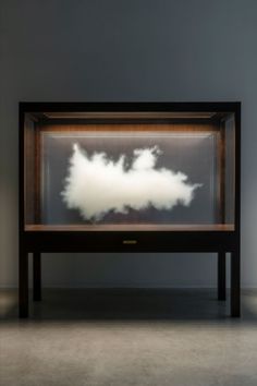 a large cloud in a glass case on top of a table