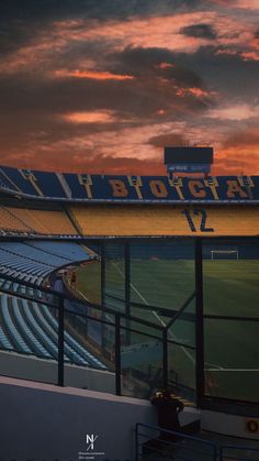 the sun is setting over an empty soccer stadium as fans sit on the bleachers