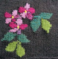 a close up of a knitted cloth with flowers on it