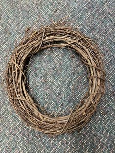 a close up of a wreath on the floor with some twigs around it and one end missing