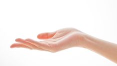 a person's hand reaching out to catch something in the air on a white background