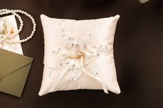 a white pillow sitting on top of a table next to pearls and other items,