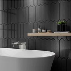 a white bath tub sitting next to a wooden shelf