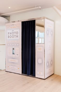 an open photo booth with curtains on the side and wooden floors in front of it