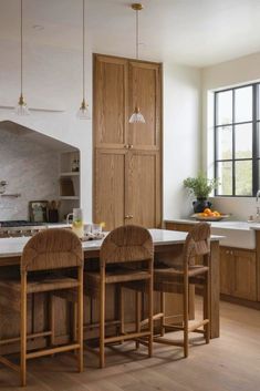 a kitchen with wooden cabinets and white counter tops next to an island in front of a window