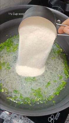 someone is pouring rice into a pot on the stove