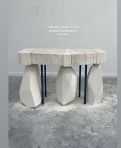 a table made out of concrete sitting on top of a cement floor next to a wall