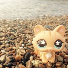 a small toy cat sitting on top of a pile of rocks