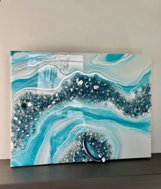 a blue and white abstract painting on a shelf