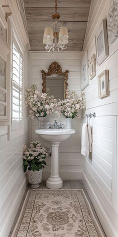 a white sink sitting under a bathroom mirror next to a rug on top of a floor